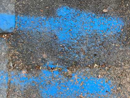 bright blue arrow spray painted markings on tarmac